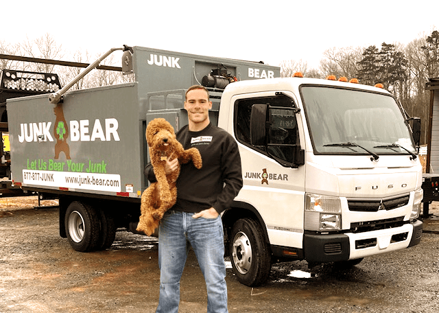 Junk removal professional in front of his truck