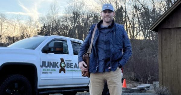 Owner and CEO of Junk Bear, Rob Paradis, standing proudly in front of his company truck