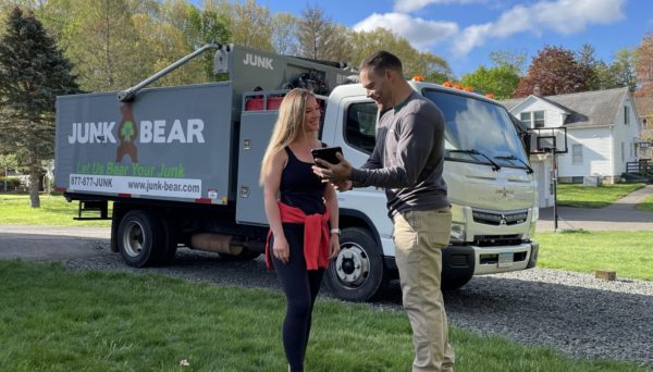 Happy customer in Redding, CT receiving a professional junk removal quote from a Junk Bear team member
