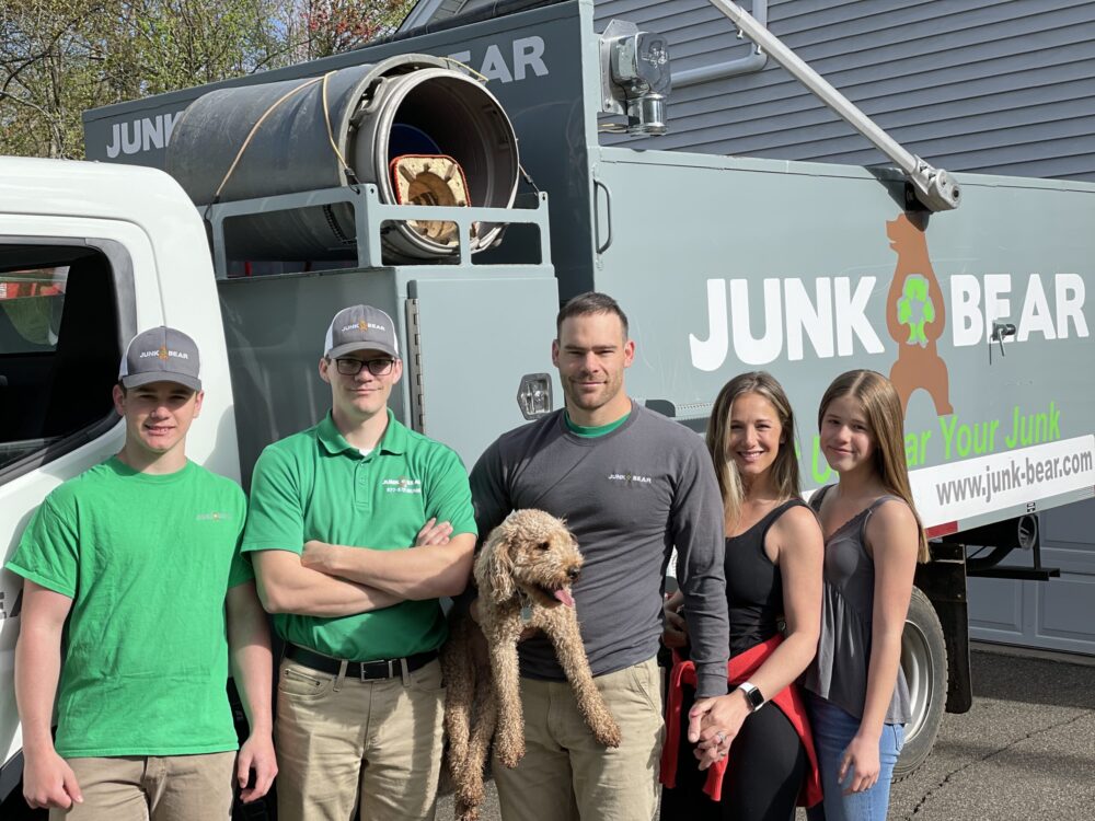 Junk Bear crew smiling next to their junk removal truck