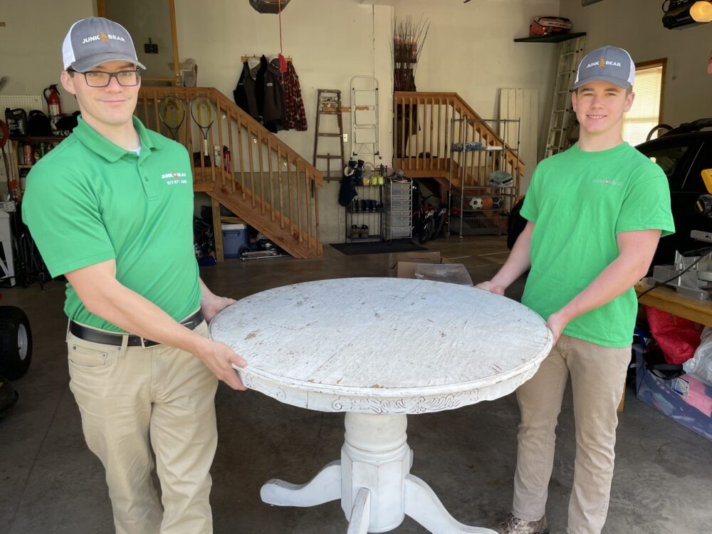Junk Bear professionals removing an old heavy table during single item pickup services