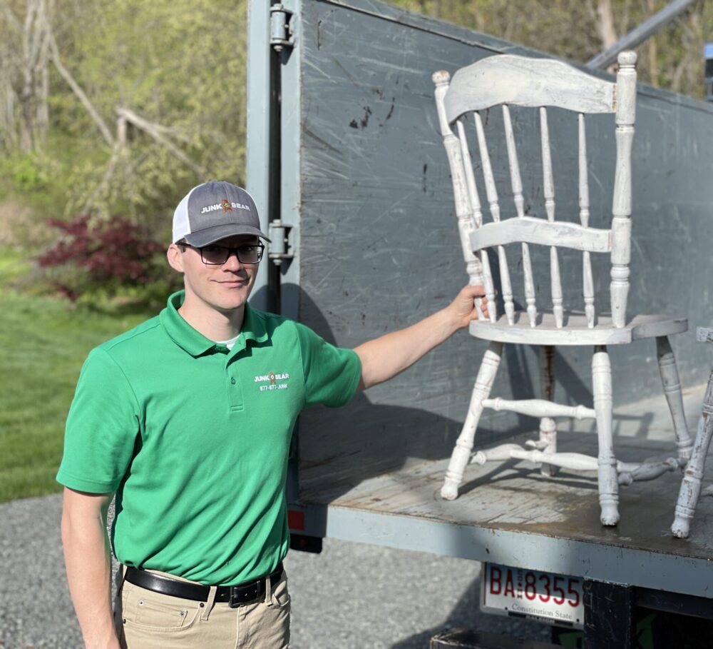 Junk Bear professional loading an old chair onto the truck during single item pickup services in CT